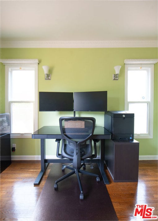 office space with dark hardwood / wood-style floors, a healthy amount of sunlight, and crown molding