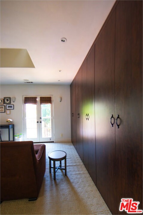 interior space with light carpet and french doors