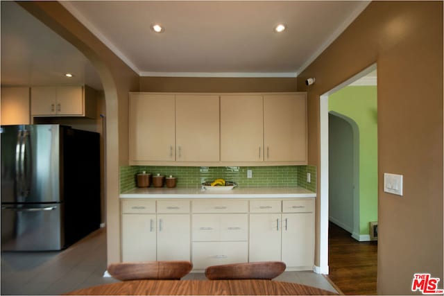 kitchen with decorative backsplash, stainless steel fridge, ornamental molding, and wood-type flooring