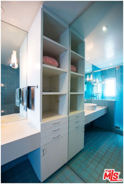 bathroom with tile patterned flooring, sink, and tile walls