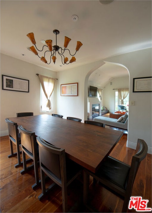 dining area featuring wood-type flooring and a notable chandelier