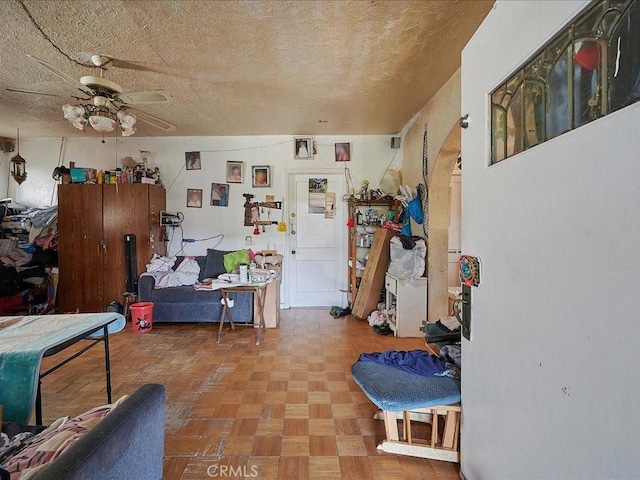 interior space featuring ceiling fan and a textured ceiling