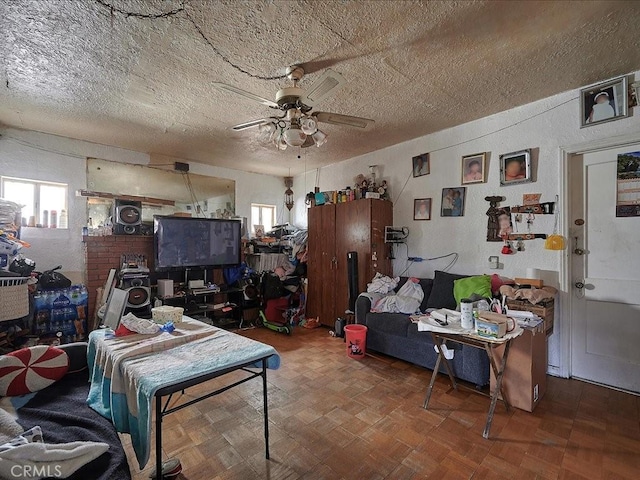 misc room featuring ceiling fan, parquet flooring, and a textured ceiling