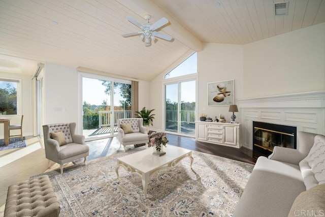 living room featuring hardwood / wood-style flooring, lofted ceiling with beams, ceiling fan, and a wealth of natural light