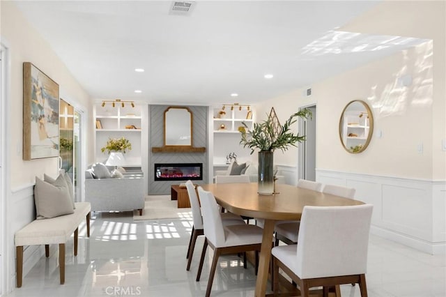 dining room with built in features and a fireplace