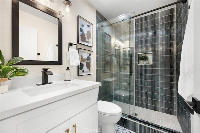 bathroom with vanity, toilet, and a shower with shower door