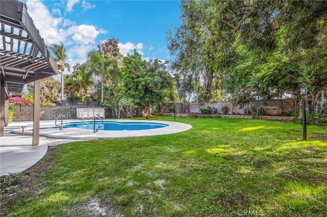 view of swimming pool featuring a yard and a patio