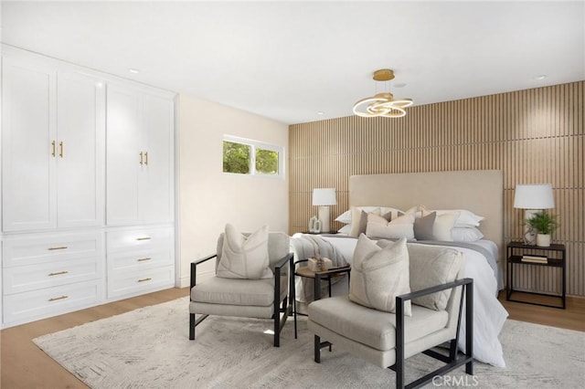 bedroom with light wood-type flooring and a notable chandelier