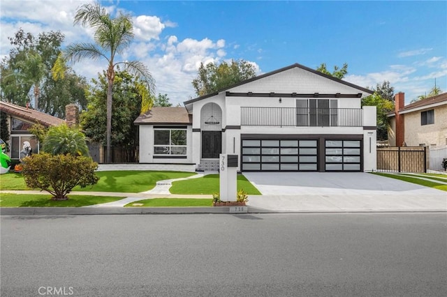 view of front of property featuring a garage, a balcony, and a front yard