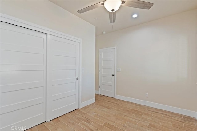 unfurnished bedroom featuring ceiling fan, light hardwood / wood-style floors, and a closet