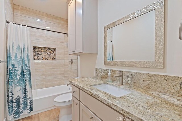 full bathroom with hardwood / wood-style flooring, vanity, toilet, and shower / bath combo