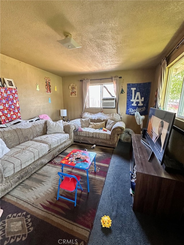 living room with a healthy amount of sunlight, a textured ceiling, carpet floors, and cooling unit