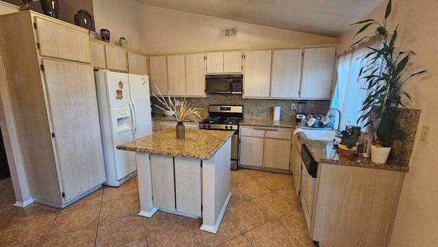 kitchen featuring light stone countertops, stainless steel stove, a kitchen island, white fridge with ice dispenser, and lofted ceiling