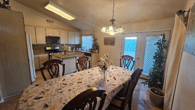 dining space featuring sink, french doors, an inviting chandelier, tile patterned floors, and lofted ceiling