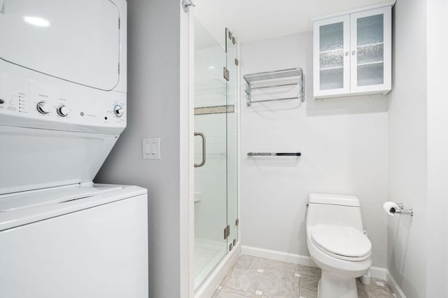 bathroom featuring stacked washer / dryer, walk in shower, and toilet