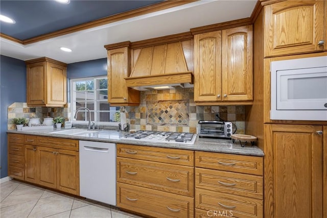 kitchen with sink, premium range hood, white appliances, decorative backsplash, and light tile patterned floors