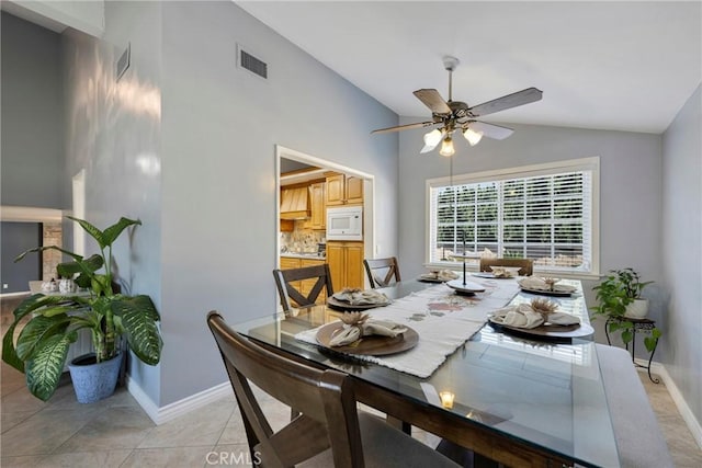 tiled dining space featuring ceiling fan and lofted ceiling