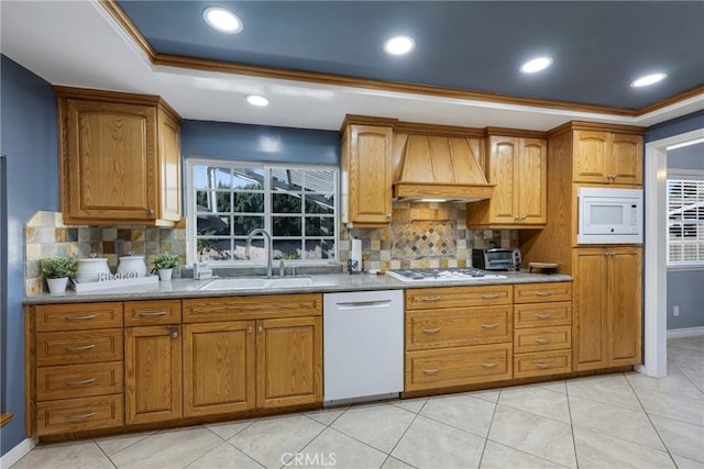 kitchen with custom range hood, white appliances, tasteful backsplash, and sink