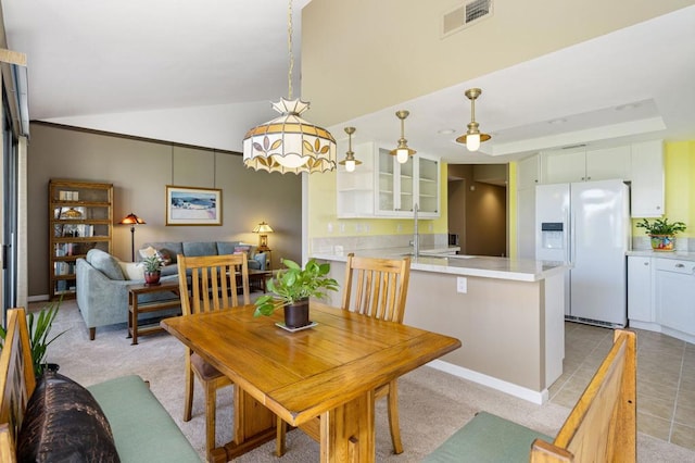 dining room with lofted ceiling and light tile patterned floors