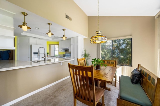 carpeted dining area featuring sink