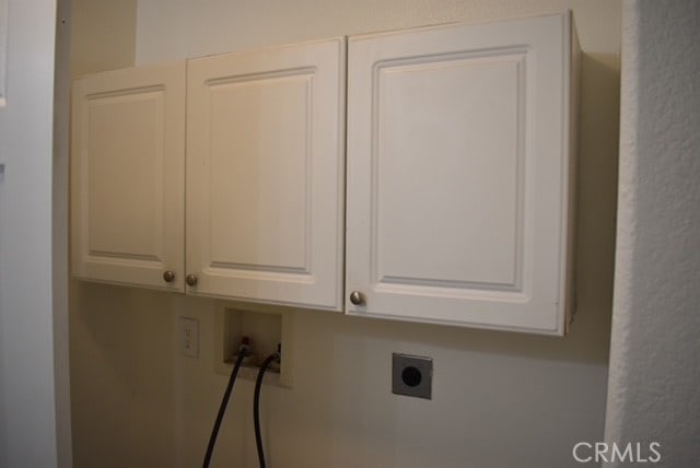 clothes washing area with cabinets, hookup for an electric dryer, and washer hookup