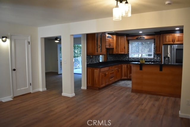 kitchen with tasteful backsplash, dark hardwood / wood-style flooring, stainless steel fridge, ceiling fan, and decorative light fixtures