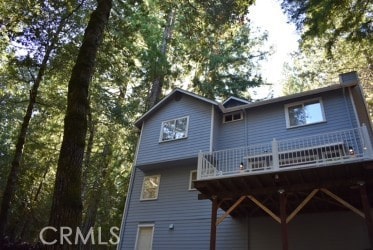 rear view of property featuring a wooden deck