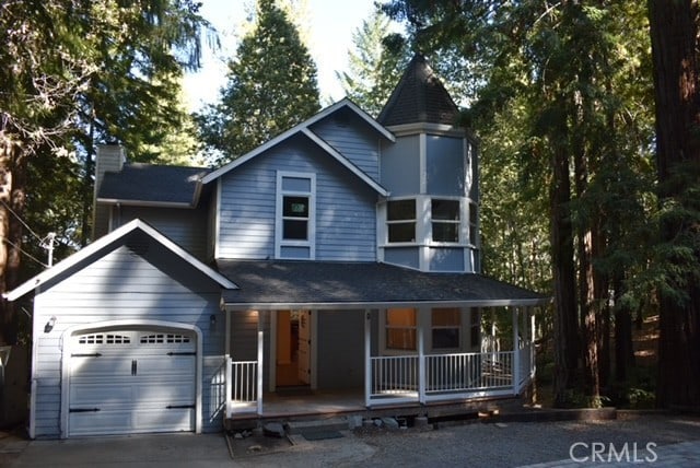 victorian home featuring covered porch and a garage