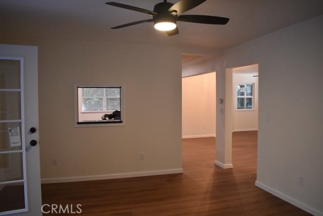 unfurnished room with ceiling fan and dark hardwood / wood-style flooring