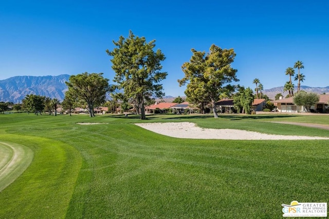 view of property's community with a mountain view and a lawn