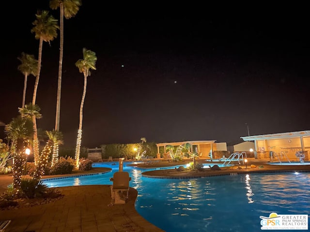 pool at twilight featuring a patio area