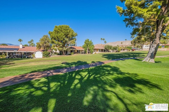 view of home's community featuring a storage shed and a lawn