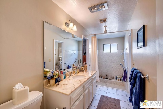 bathroom featuring a textured ceiling, toilet, vanity, curtained shower, and tile patterned flooring