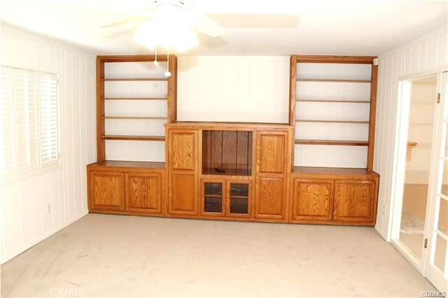 unfurnished living room featuring light carpet and ceiling fan