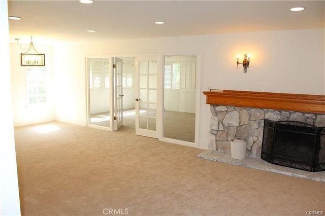 living room featuring carpet, a wealth of natural light, and a fireplace