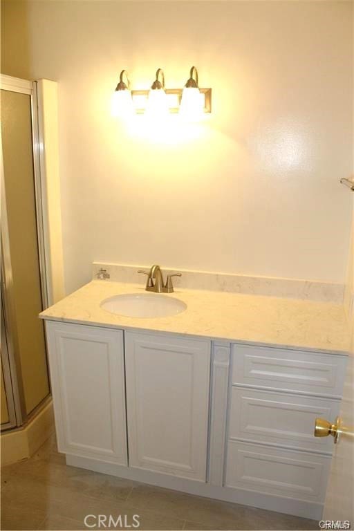 bathroom featuring vanity, tile patterned floors, and a shower with shower door