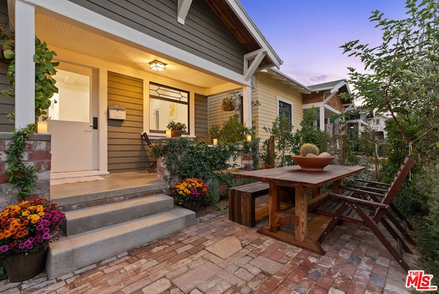 exterior entry at dusk featuring covered porch