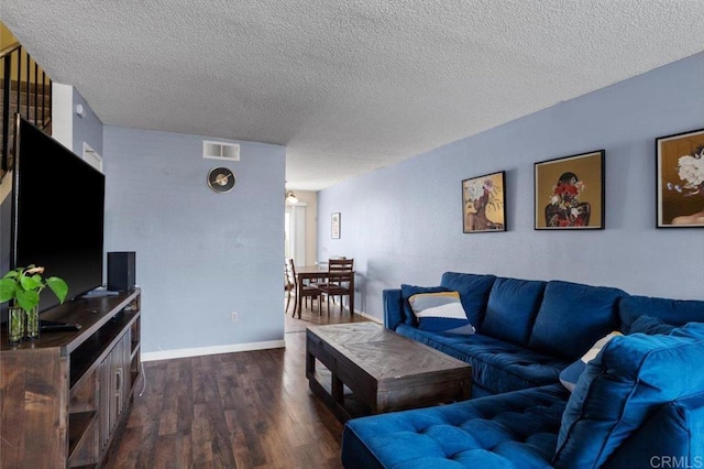 living room with dark hardwood / wood-style flooring and a textured ceiling