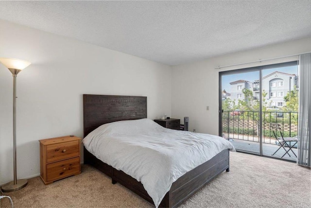 bedroom with carpet, a textured ceiling, and access to outside