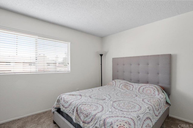 bedroom featuring carpet flooring and a textured ceiling