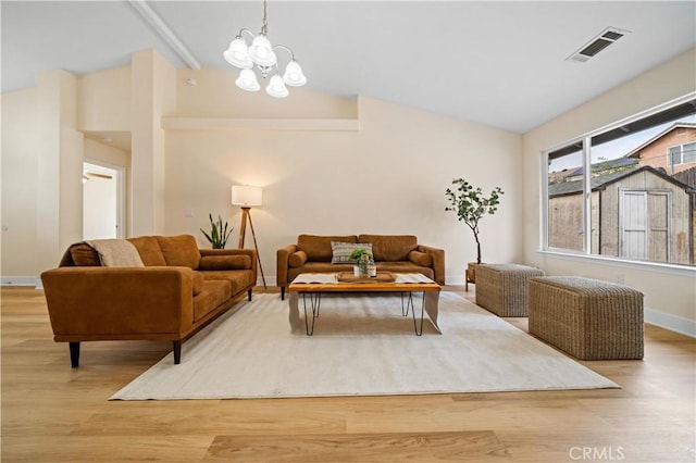 living room with an inviting chandelier, high vaulted ceiling, and light wood-type flooring