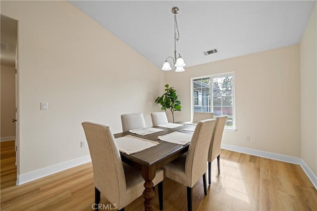 dining space with a notable chandelier and light hardwood / wood-style floors