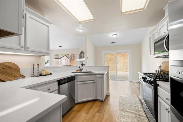 kitchen featuring sink, white cabinets, stainless steel appliances, and plenty of natural light