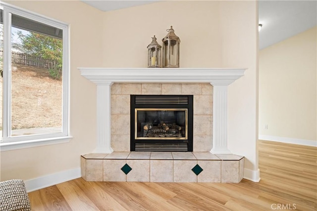 room details featuring a tile fireplace and hardwood / wood-style flooring