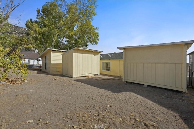 back of house featuring a storage unit