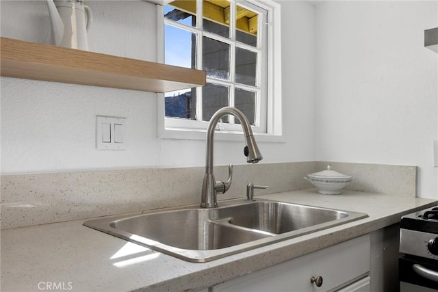 kitchen featuring light stone counters and sink