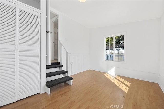 staircase with hardwood / wood-style floors and vaulted ceiling