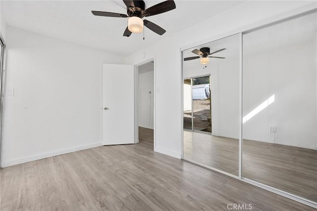 unfurnished bedroom featuring a closet, light hardwood / wood-style flooring, and ceiling fan