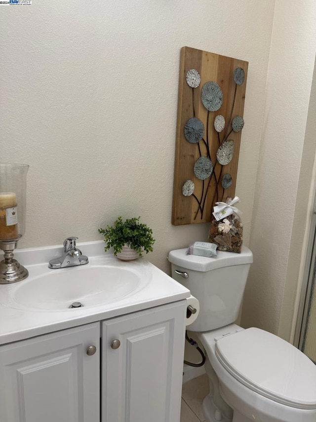 bathroom with tile patterned floors, vanity, and toilet