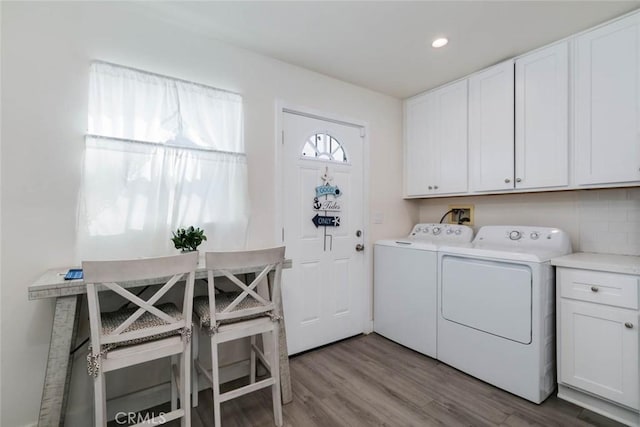 laundry area with cabinets, light hardwood / wood-style floors, and washer and clothes dryer